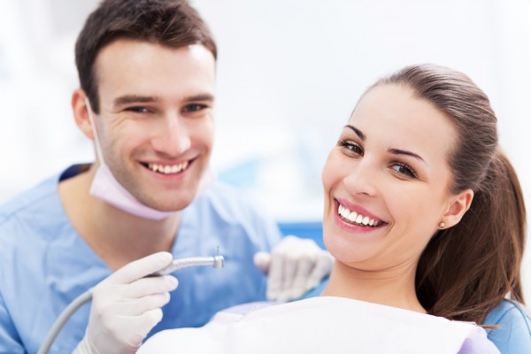 Dentiste et patiente qui arborent des sourires blancs