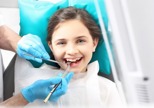 Petite fille se faisant examiner par un dentiste
